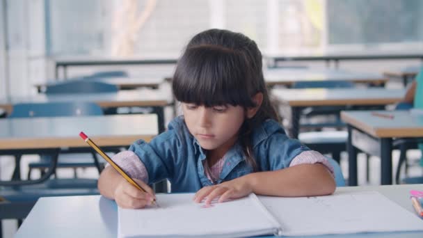 Ученица начальной школы держит в руках карандаш - Кадры, видео