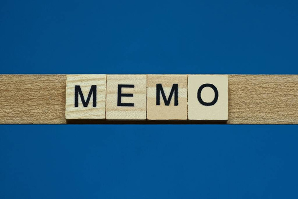 szürke szó memo kis négyzet alakú fa betűkkel, fekete betűtípussal, kék háttérrel - Fotó, kép
