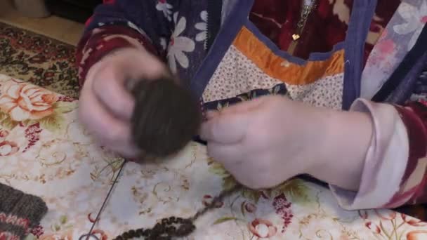 een oudere vrouw breit met breinaalden van wol - Video