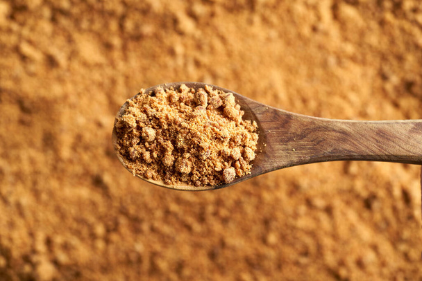 A spoonful of panela or rapadura - healthy sweetener made by evaporating sugercane juice, top view - Photo, Image