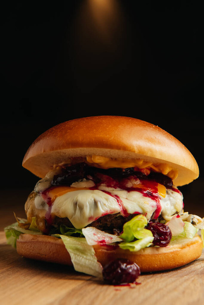 Unusual burger with cherry jam, meat and green salad - 写真・画像