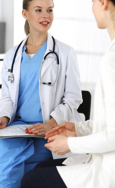 Woman - doctor consults her female patient while using clipboard and medication history record. Medicine concept - Foto, Imagem
