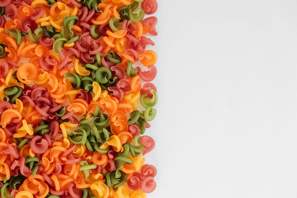 Multicolored pasta scattered on a white background. Top view. Copy, empty space for text. - Photo, Image
