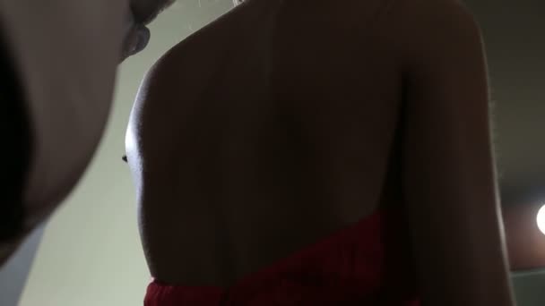 Egy férfi kibontja egy vörös ruhás lány haját. Haj hullik a lány hátára. - Felvétel, videó