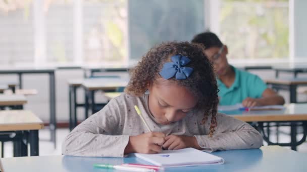 Εστιασμένη μαύρη μαθήτρια δημοτικού χρησιμοποιώντας στυλό - Πλάνα, βίντεο