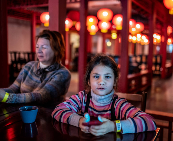 abuela y nieta en un restaurante chino intercambio impresiones - Foto, Imagen