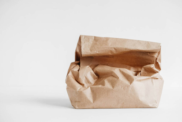 Full crumpled disposable bag of brown kraft paper on a white background. Copy, empty space for text. - Photo, Image