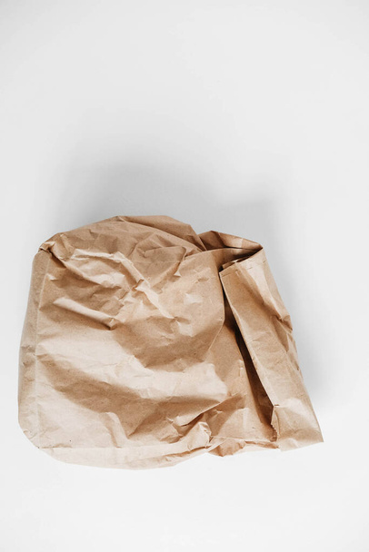 Full crumpled disposable bag of brown kraft paper on a white background. Top view. Copy, empty space for text. - Photo, Image