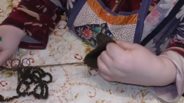 een oudere vrouw breit met breinaalden van wol - Video