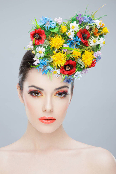 Portret piękności. Piękna dziewczyna z wiosennymi kolorowymi kwiatami. Piękna Twarz. Kreatywny makijaż i styl włosów. - Zdjęcie, obraz