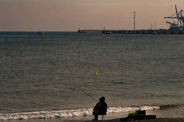 fisherman by the sea with fishing rod in the western Ligurian Riviera - Photo, Image