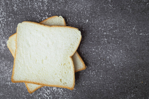 Pane affettato su sfondo scuro grunge per panetteria, cibo e concetto di mangiare - Foto, immagini