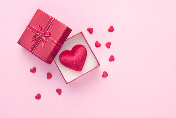 Gift box and red heart on pink background with copy space for love wedding or valentines day. - Fotó, kép