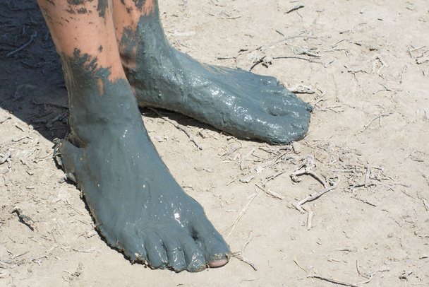 Çamuru iyileştiren kadın ayakları. İnsan sağlığı için kozmetoloji ve balneoloji. - Fotoğraf, Görsel