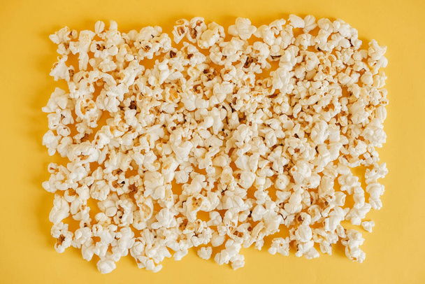 Popcorn on a yellow background as a background image. Top view. Copy, empty space for text. - 写真・画像