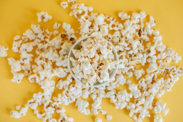 Popcorn in paper cup on a yellow background. Top view. Copy, empty space for text. - Zdjęcie, obraz