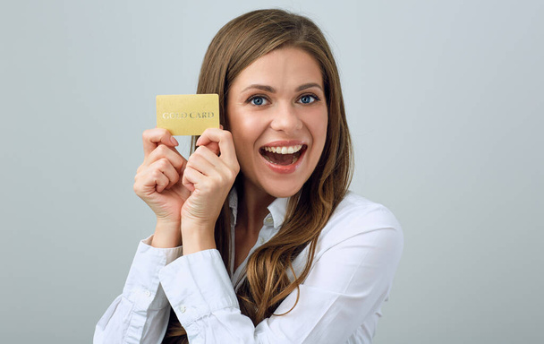 Happy woman in white shirt holding credit card. isolated female person portrait. - Fotó, kép