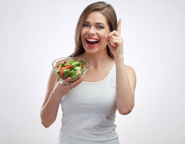 Dedo apontando para cima. Estilo de vida saudável isolado retrato de mulher sorridente segurando salada vegetal. - Foto, Imagem