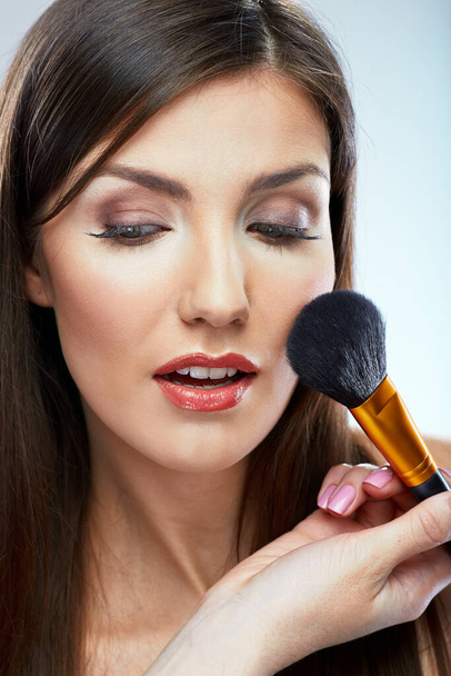 Beautiful woman using brush for make up applying. Isolated portrait. - Photo, Image