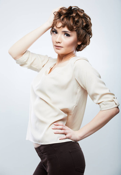 young woman with short hair posing on isolated studio background. - Фото, зображення