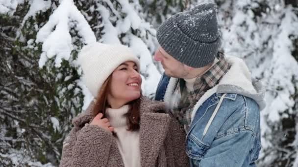 αγάπη και την έννοια της ευτυχίας - κοντά του ευτυχισμένο ζευγάρι αγκαλιάζει και φιλιά στο δάσος του χειμώνα - Πλάνα, βίντεο