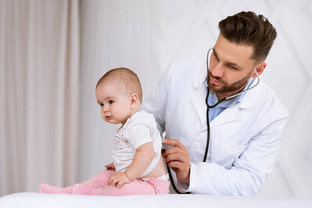 Arzt untersucht Kleinkind mit Stethoskop in Klinik - Foto, Bild