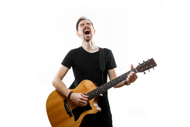 Guitarrista tocando y cantando en voz alta sobre un fondo blanco aislado - Foto, imagen