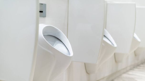 Urinos operados por sensores com paredes de privacidade em um banheiro público masculino - Foto, Imagem