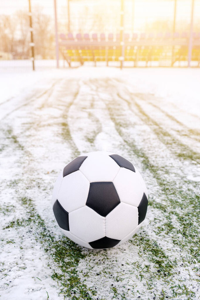 Ποδόσφαιρο μπάλα στο χιονισμένο γρασίδι το χειμώνα - Φωτογραφία, εικόνα