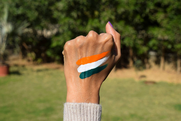 Tatuaje de bandera india de color tri pintado en la mano de la persona animando y celebrando el día de la república india - Foto, imagen