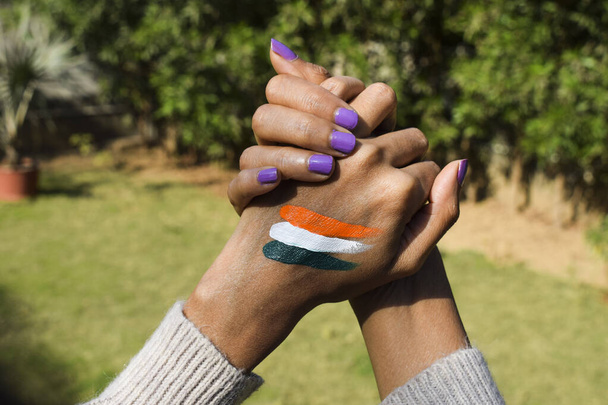 Tatuaje de bandera india de color tri pintado en la mano de la persona animando y celebrando el día de la república india - Foto, Imagen