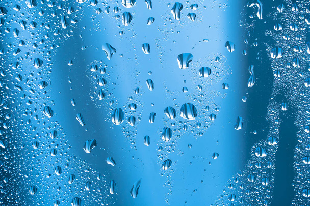 Krople deszczu na szkle w deszczową pogodę.Błyszcząca, błyszcząca powierzchnia wody na szkła.Krople wody w postaci kulek lub kul.Szare tło krople deszczu. Abstrakcyjne tła ozdoba z wodą - Zdjęcie, obraz