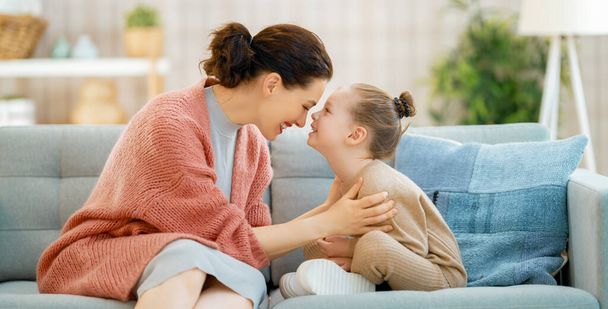 Mom and her daughter child girl are playing, smiling and hugging at home.  - Foto, imagen