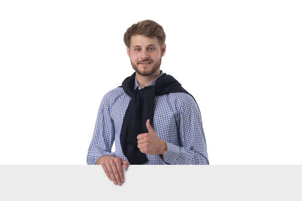 Portrait of happy smiling casual man holds blank board and shows thumbs up isolated on white background - Фото, изображение