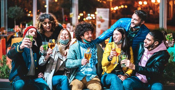 Menschen trinken Spritz und Mojito an der Cocktailbar mit offener Gesichtsmaske - Neues normales Freundschaftskonzept mit glücklichen Freunden, die gemeinsam Drinks im Outdoor-Restaurant prosten - Hohes Iso-Image - Foto, Bild