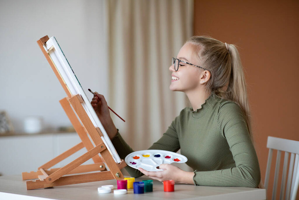 Ταλαντούχο κορίτσι κρατώντας παλέτα και πινέλο, ζωγραφική - Φωτογραφία, εικόνα