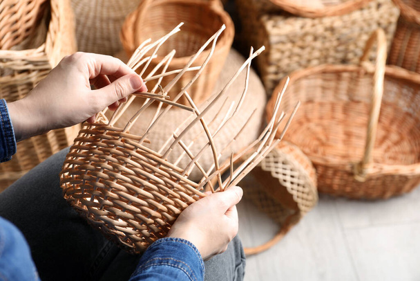 Woman weaving wicker basket indoors, closeup view - Fotografie, Obrázek