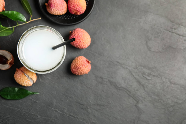 Fresh lychee juice and fruits on grey table, flat lay. Space for text - Zdjęcie, obraz