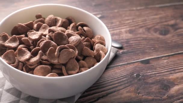 Top view of chocolate corn flakes in a bowl on wooden table  - Footage, Video