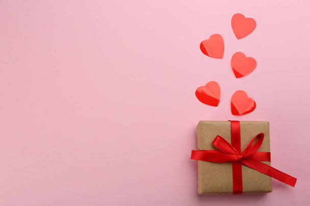 Beautiful gift box and hearts on pink background, flat lay with space for text. Valentine's day celebration - 写真・画像