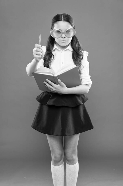 inspiration for writing. get information from book. happy school girl in uniform and party glasses. small child with notebook. literature lesson education. writing in workbook. children literature - Фото, зображення
