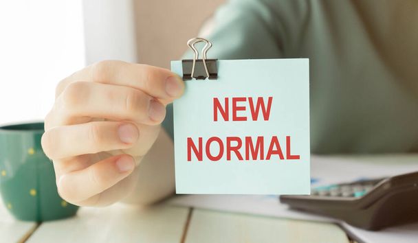 New normal concept effected by COVID 19 coronavirus that changes our lifestyle to new normal presented in word written in notebook on office desk when abnormal becomes new normal . - Foto, imagen