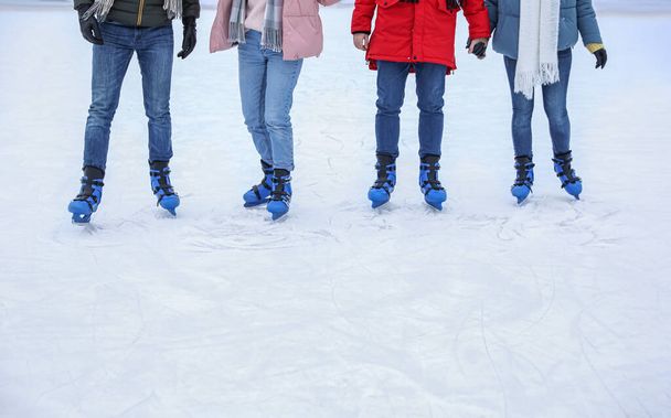 Friends skating along ice rink outdoors, closeup. Space for text - Photo, image