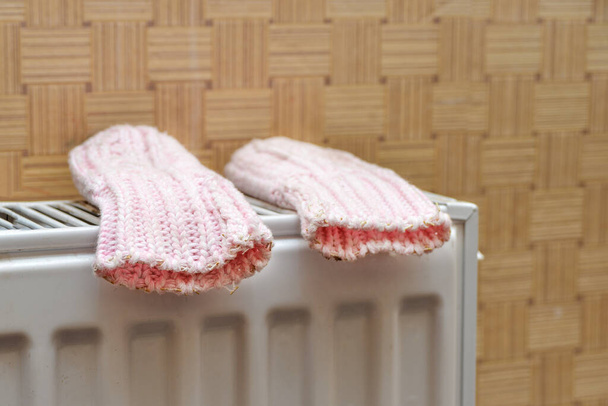 Baby pink mittens dry on the heater after the baby's winter walk. - Photo, Image