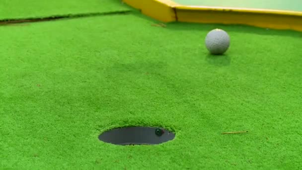 Giocatore di golf in azione di mettere una palla da golf sulla corsa verde attraverso un buco con successo - Filmati, video