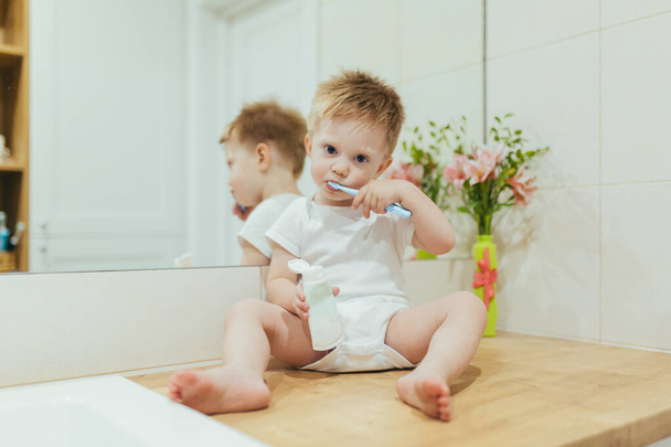 Little kid boy brushing teeth in his bathroom, baby taking care of teeth - Foto, imagen