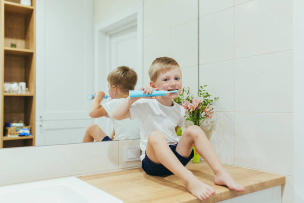 Little kid boy brushing teeth in his bathroom, baby taking care of teeth - 写真・画像