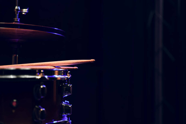 Onderdeel van een drumstel in het donker met mooie verlichting. Concert- en prestatieconcept. - Foto, afbeelding