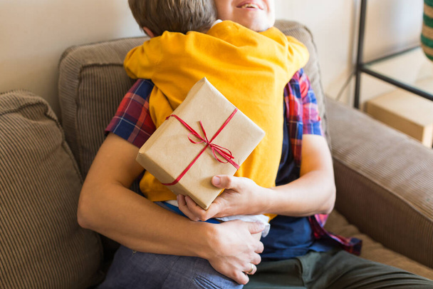 Den svátků otců. Roztomilý chlapec dává ručně vyrobenou dárkovou krabici svému otci. Happy family, time together, stay at home. - Fotografie, Obrázek