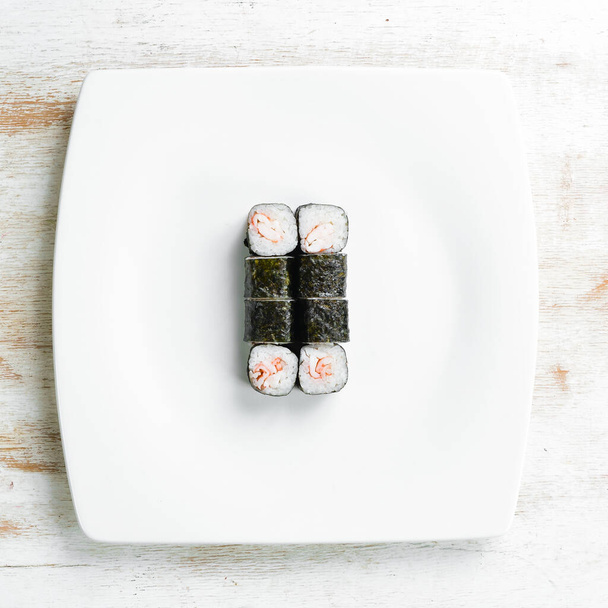 Asian cuisine. Sushi maki on a white plate. Top view. On a white background. - Valokuva, kuva